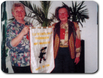 Ursula Schmidt überreicht Johanna Köhring eine Fahne zum 15-jährigen Bestehen der Abteilung (1997)
